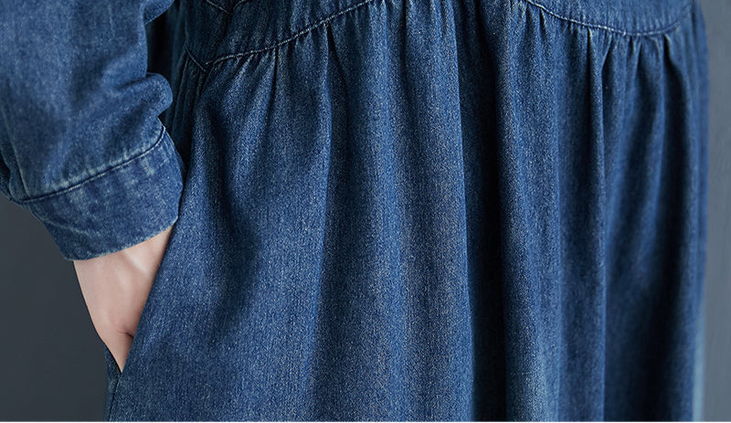 Close-up of a blue denim skirt worn by a person with white sneakers on a neutral background